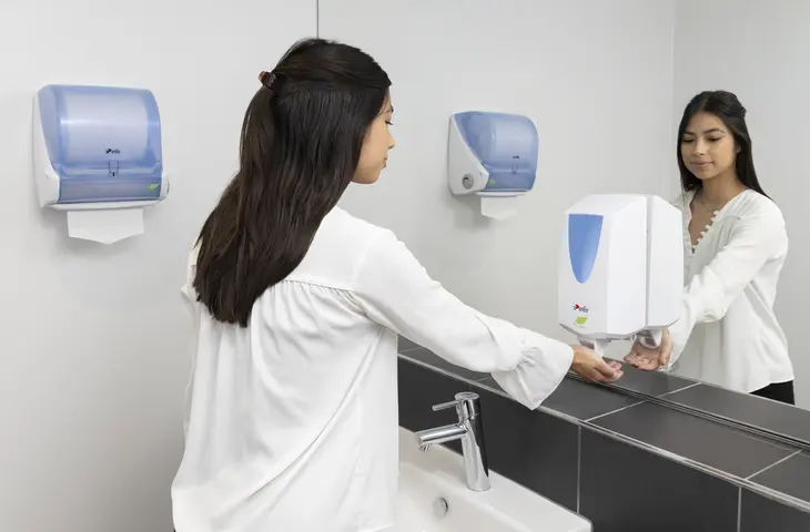 Jeune fille et distributeur de savon mousse avec réserve